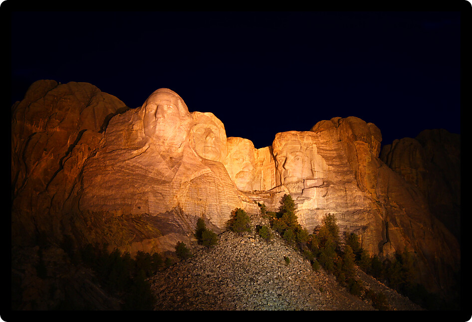 Mount Rushmore National Memorial illuminated at night in South Dakota.