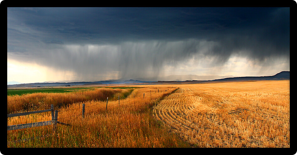 Dark storm clouds thunder across the plains of rural Montana on a fall day.