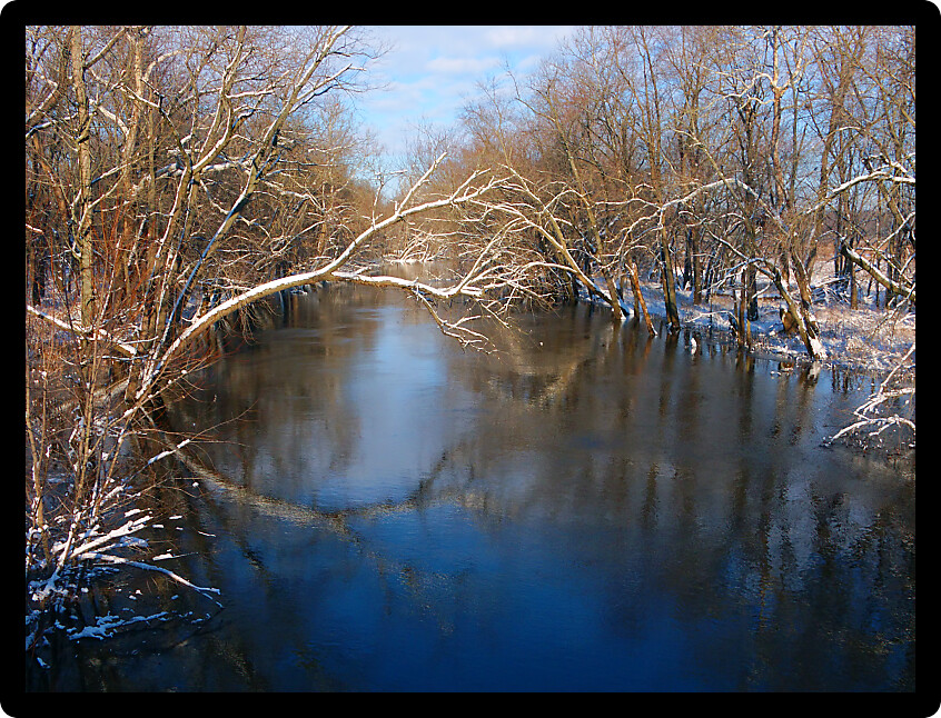 Sangamon River in Piatt County Illinois under a brilliant blue sky.