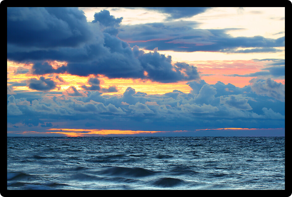 Sunset over crashing waves of Lake Superior along a northern Michigan shoreline.