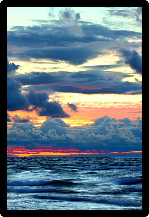 Sunset over crashing waves of Lake Superior along a northern Michigan shoreline.