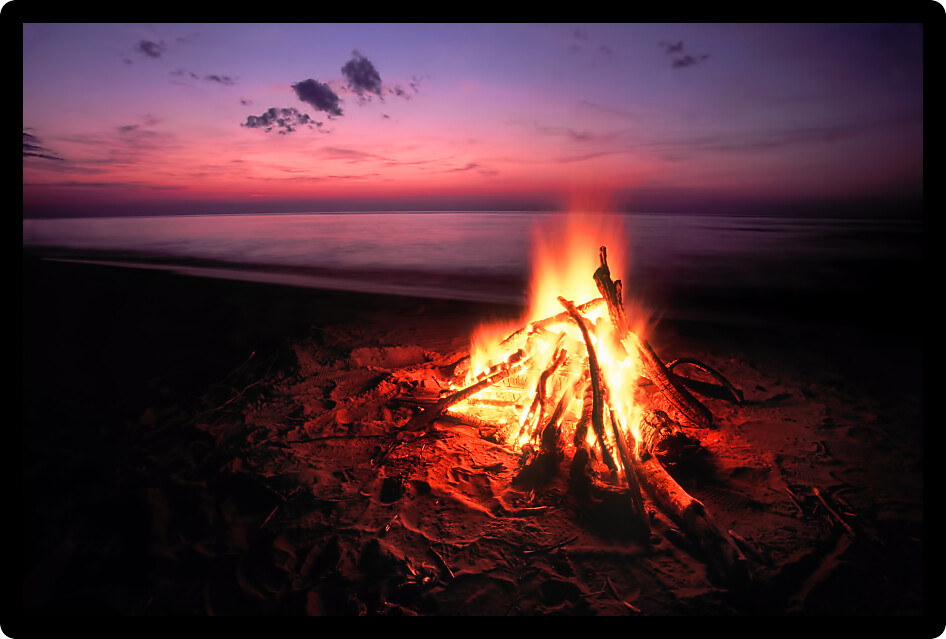 Blazing campfire at sunset along the beautiful beach of Lake Superior in northern Michigan.