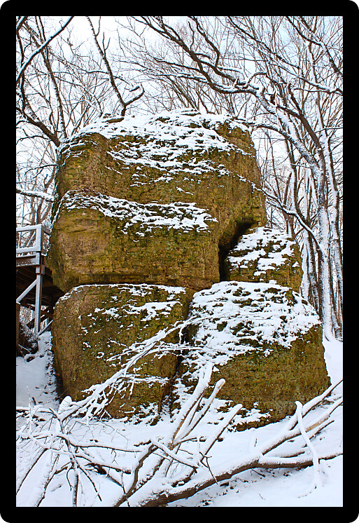 Big Rock at Rock Cut State Park in a snow covered forest.