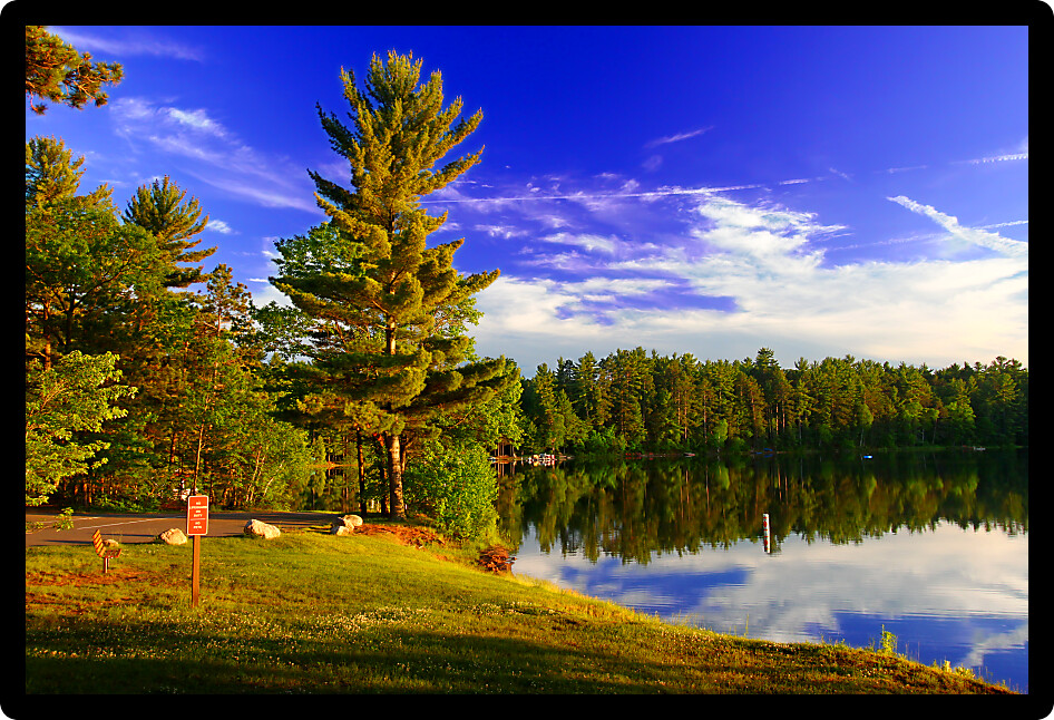 Evening sunlight illuminates the shoreline of a crystal clear northwoods Wiscconsin lake.