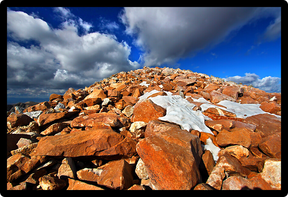 Giant boulders and patchy snow at the rugged summit of Medicine Bow Peak in Wyoming.