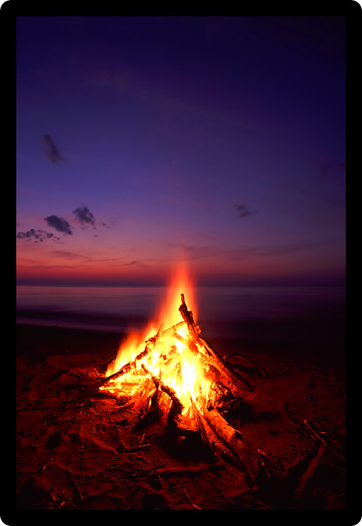 Blazing campfire at sunset along the beautiful beach of Lake Superior in northern Michigan.