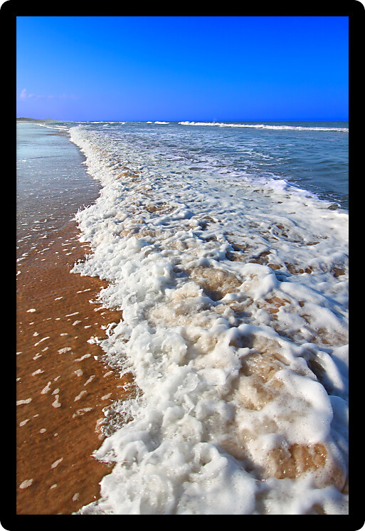 Waves crash along the coast on a beautiful day in Daytona Beach Florida.