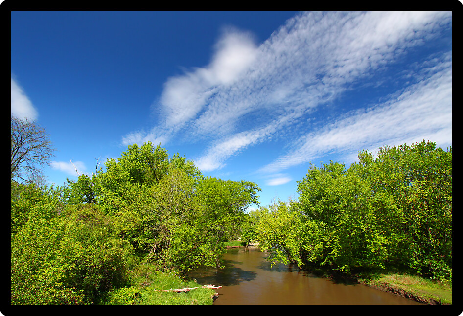 Fair weather clouds on a spring day over the Kishwaukee River of Illinois.
