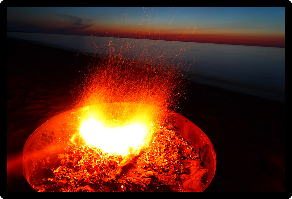 Blazing campfire at sunset along the beautiful beach of Lake Superior in northern Michigan.