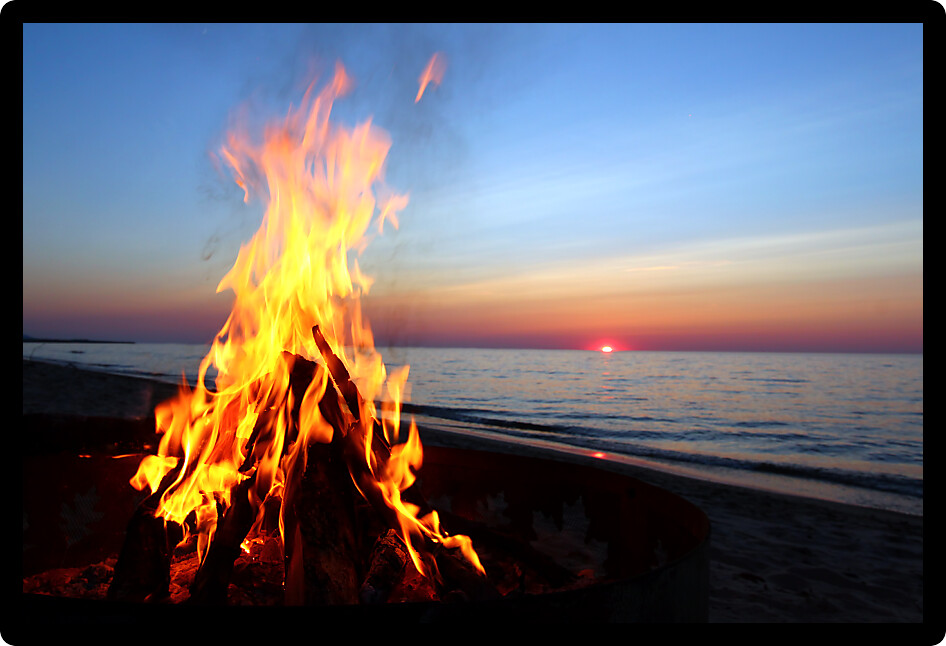 Blazing campfire at sunset along the beautiful beach of Lake Superior in northern Michigan.