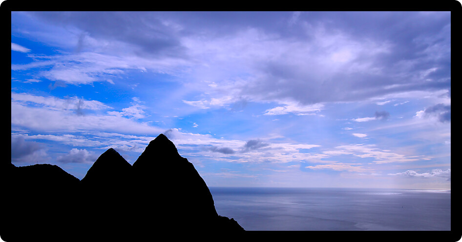 Famous Pitons of Saint Lucia silhouetted against the sky.