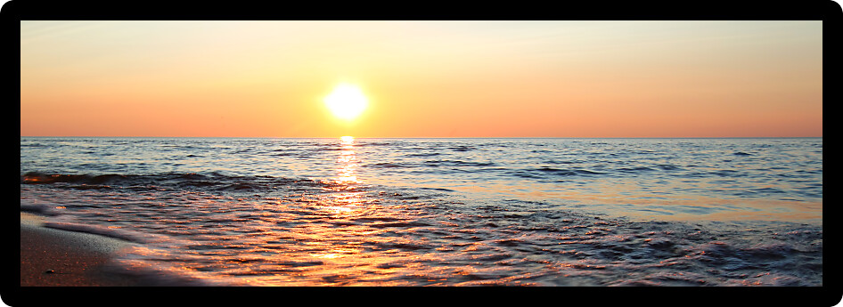 Panoramic view of waves washing ashore at sunset along beautiful Lake Superior.
