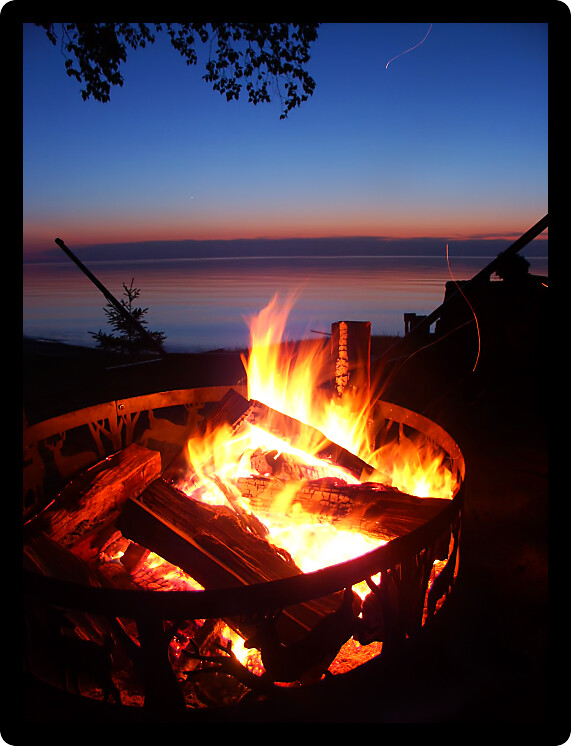 Blazing campfire at sunset along the beautiful beach of Lake Superior in northern Michigan.