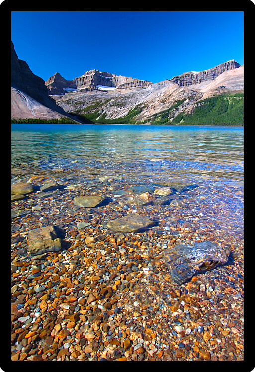 Rocky substrate visible under clear waters of Bow Lake in Banff National Park of Canada.