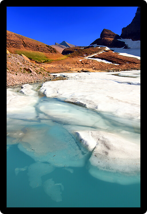 Ice floats in melting water of the Grinnell Glacier in Glacier National Park of Montana.