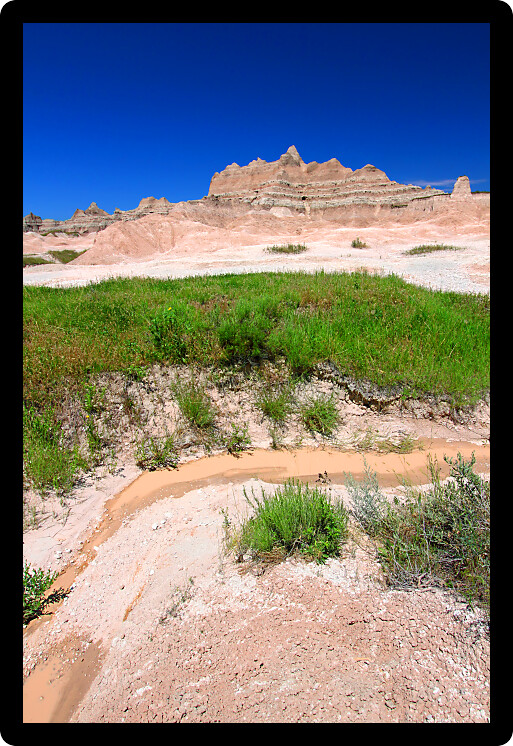 Small stream of muddy water in Badlands National Park of South Dakota.
