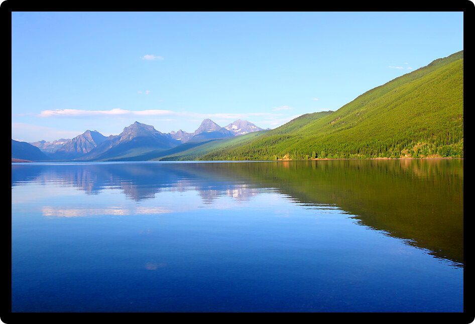 Mountains reflect off Lake McDonald on a calm evening in Glacier National Park.