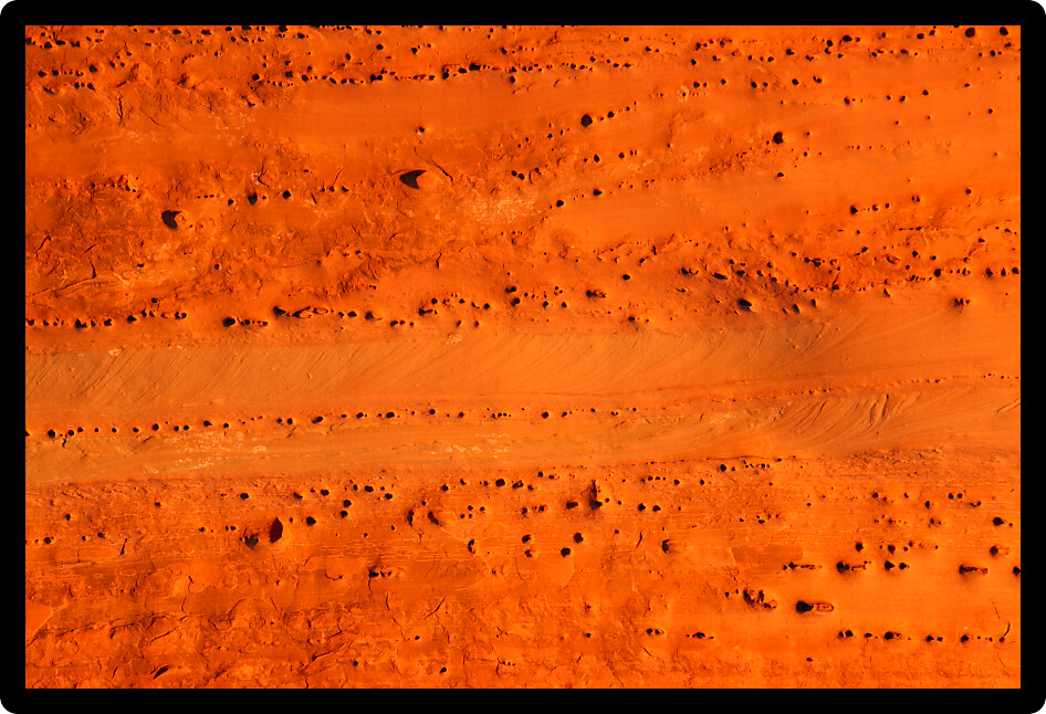 Bright orange rocks of Arches National Park illuminated in evening sunlight.