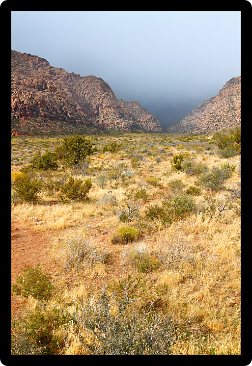 Dark clouds loom between mountain peaks at Red Rock Canyon National Conservation Area in Nevada.