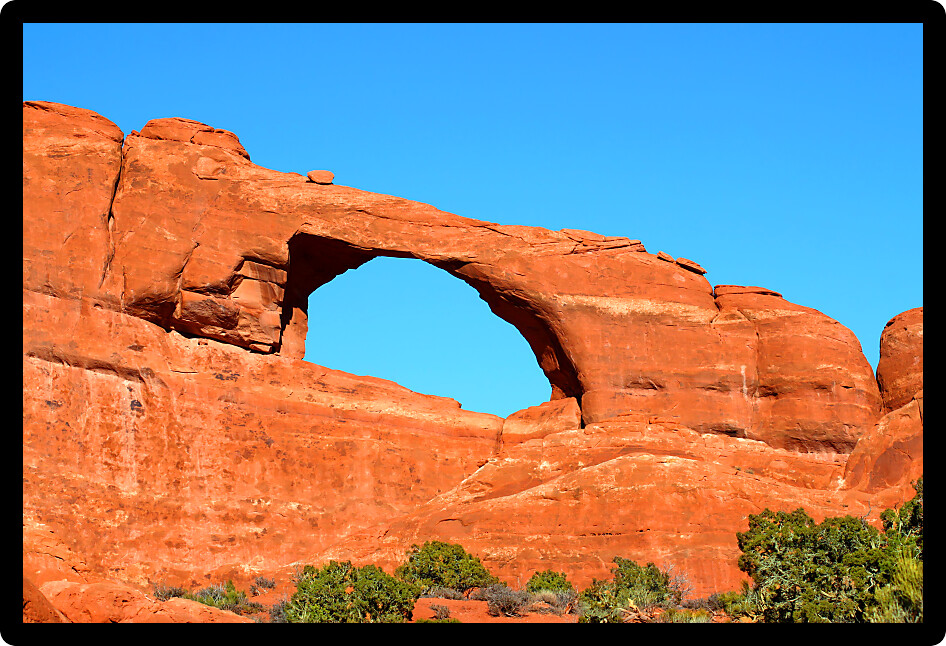 Skyline Arch stretches over a rocky landscape at Arches National Park of Utah.